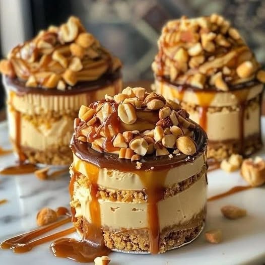 Mini cheesecakes cremosos con salsa de caramelo encima y un toque de sal marina, servidos sobre cápsulas de papel.