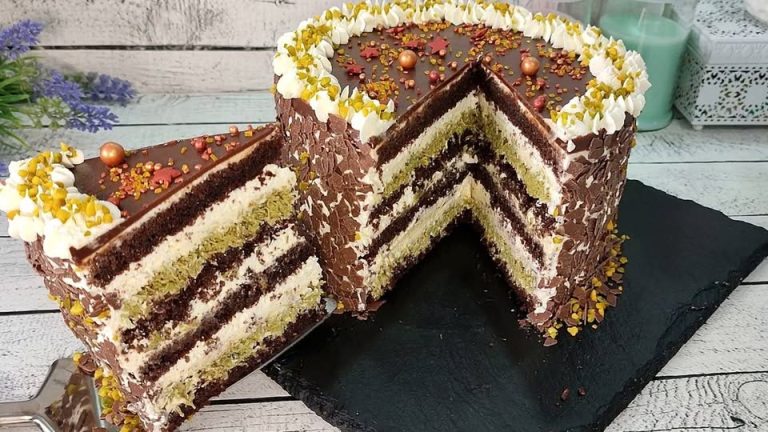 Pastel de chocolate con capas de bizcocho esponjoso, crema suave, pistacho crujiente y glaseado brillante.