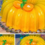 Pastel casero de mandarina esponjoso y dorado, relleno con una suave crema cítrica, decorado con rodajas de mandarina y espolvoreado con azúcar glas.