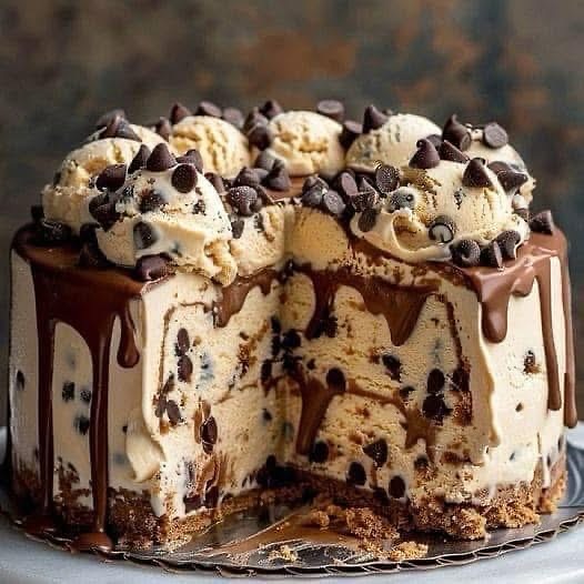 Pastel helado de masa de galleta con chispas de chocolate, decorado con ganache y trocitos crujientes sobre una base de galleta.