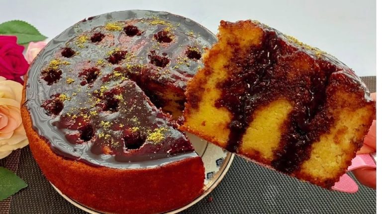 Pastel esponjoso de naranja cubierto con ganache de chocolate brillante y decorado con pistaches triturados.